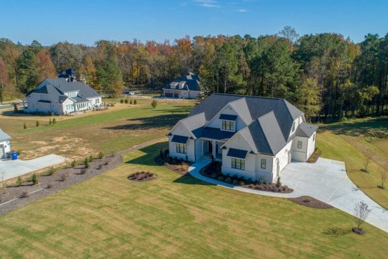 custom home surrounded by tall trees in a luxury neighborhood