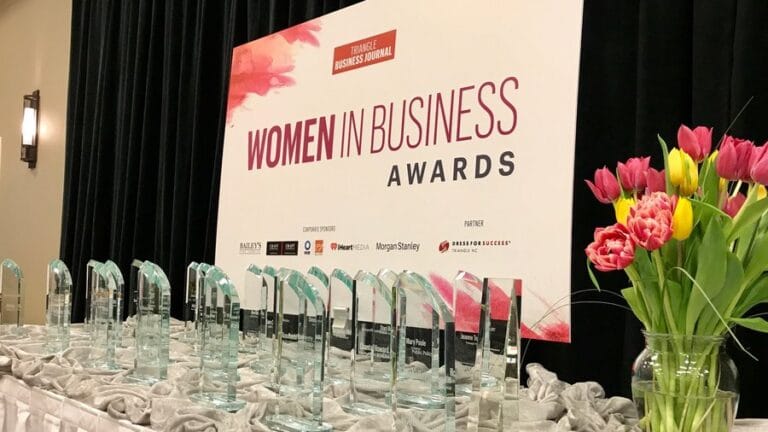 a poster for women in business with flowers next to it